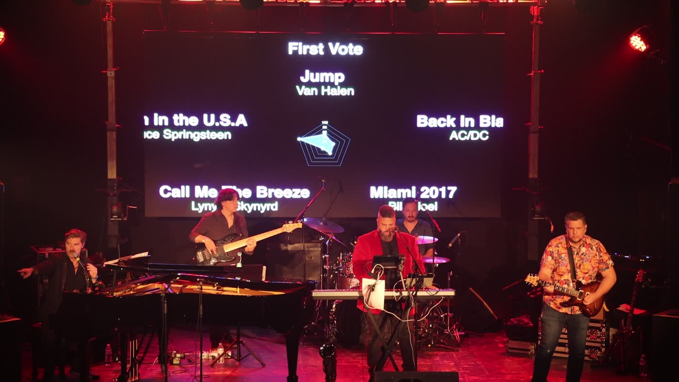 The first-round ballot projected behind the band
